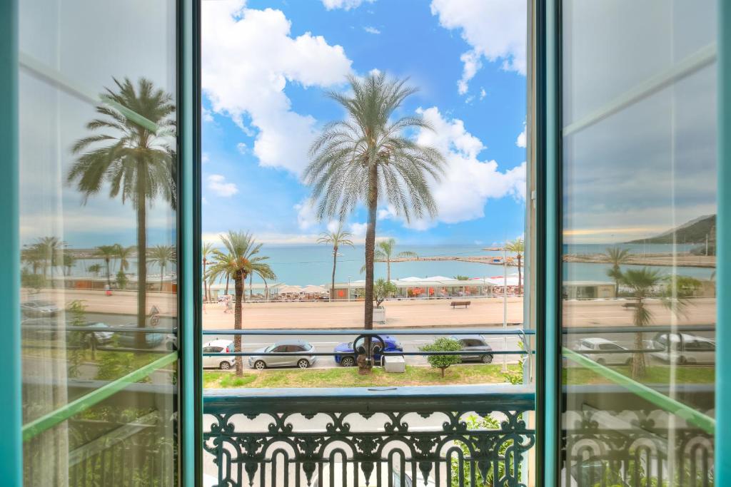 - une vue sur la plage et les palmiers dans l'établissement Casamare Sea View - Happy Rentals, à Menton