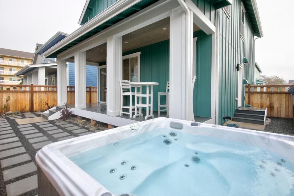 a hot tub on a patio with a house at Gardener's Getaway in Ocean Shores