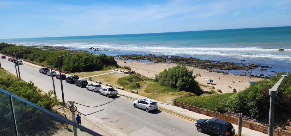 a road with cars parked on the beach at Quequen - Vista al Mar in Quequén