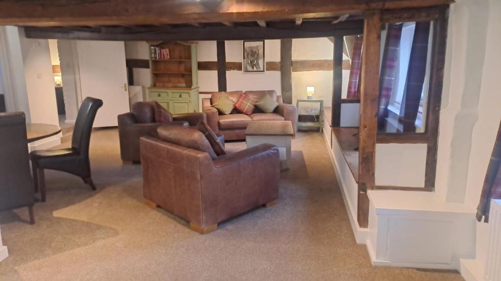 ein Wohnzimmer mit zwei Sofas und einem Tisch in der Unterkunft Charming Four Person Malthouse Apartment in Much Wenlock