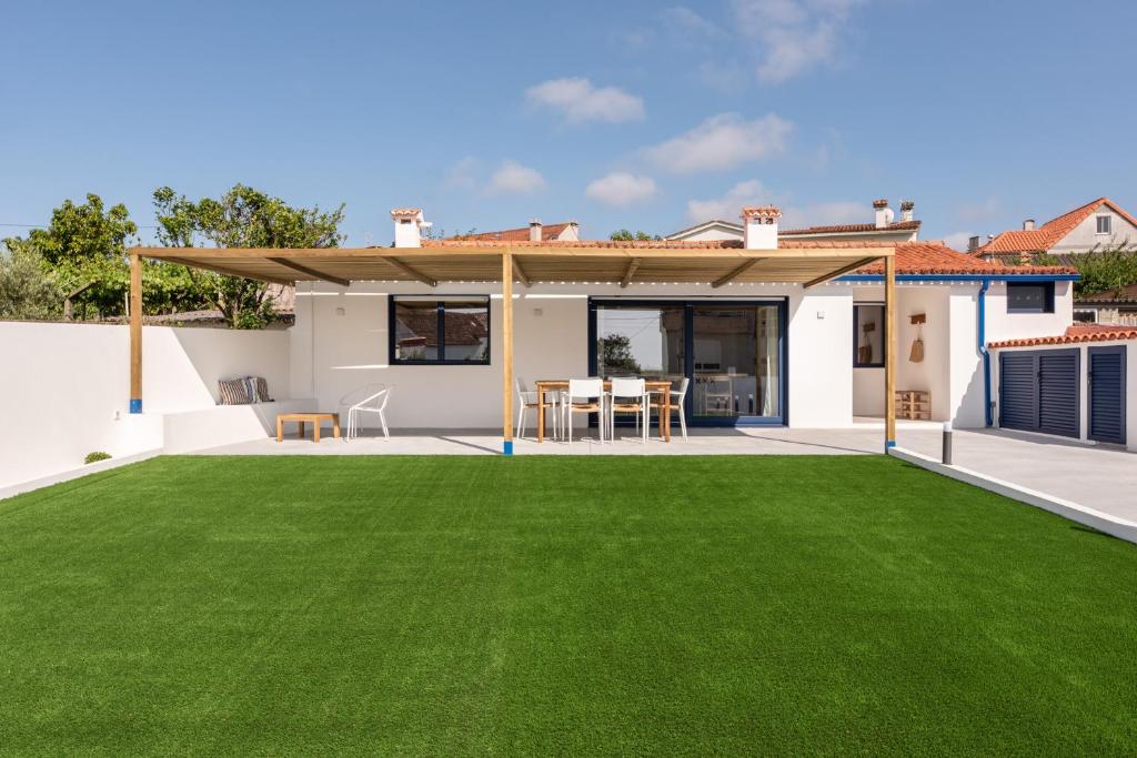 a backyard with a green lawn in front of a house at A Casiña in Nigrán