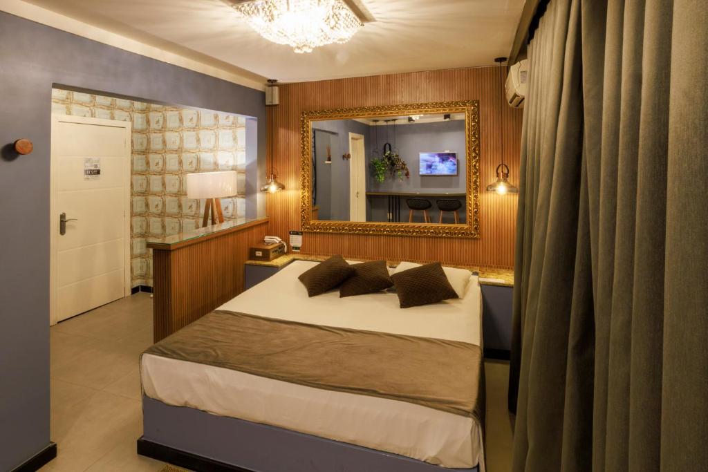 a bedroom with a large bed and a mirror at Hotel e Motel Paradiso - Passo Fundo-RS in Passo Fundo