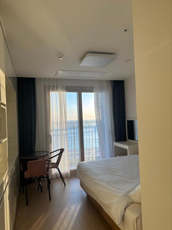 a bedroom with a bed and a desk and a window at E7 Yangyang Jukdo in Yangyang