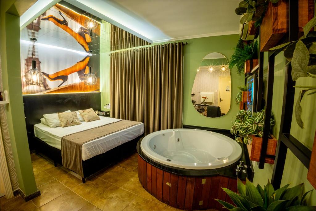 uma casa de banho com uma banheira e uma cama. em Motel Hotel Paradiso - Passo Fundo-RS em Passo Fundo