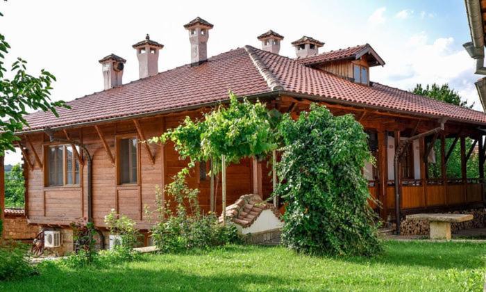 a large wooden house in a field of grass at Престиж in Arbanasi