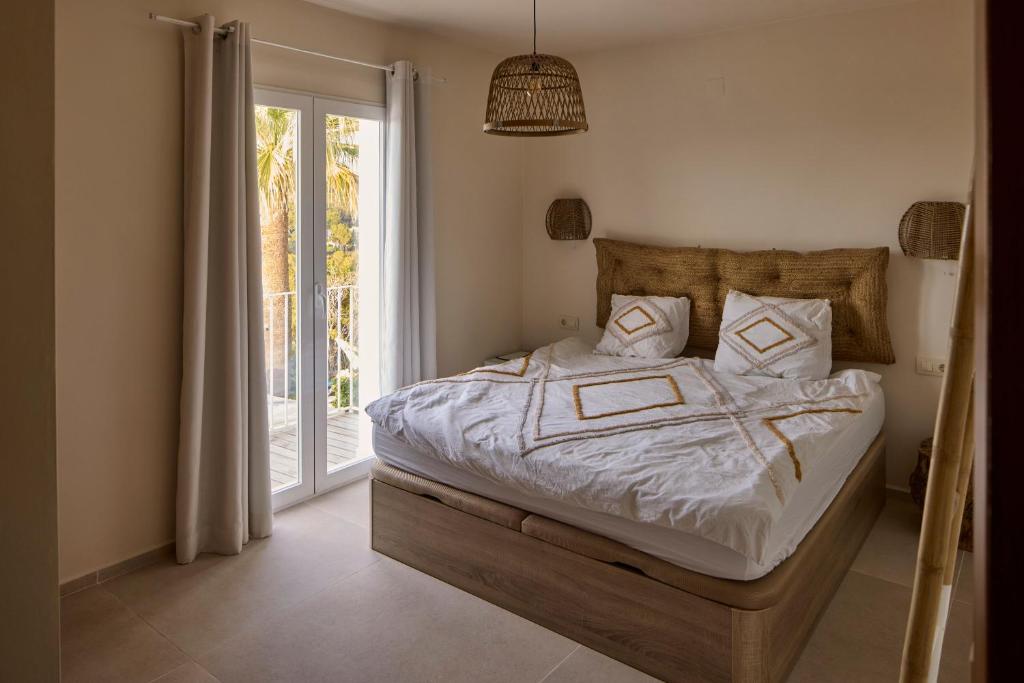 a bedroom with a bed and a sliding glass door at Casa El Sueño in Jávea