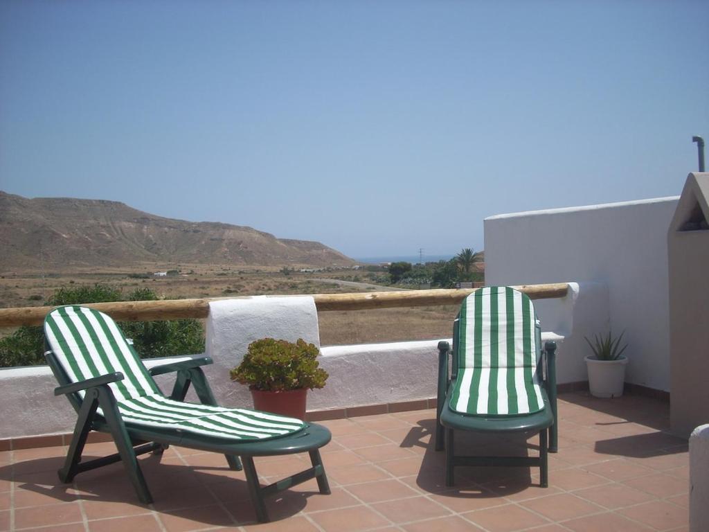 zwei grüne und weiße Stühle auf einer Terrasse in der Unterkunft LOFT IN VaLLEY RODALQUILAR in Rodalquilar