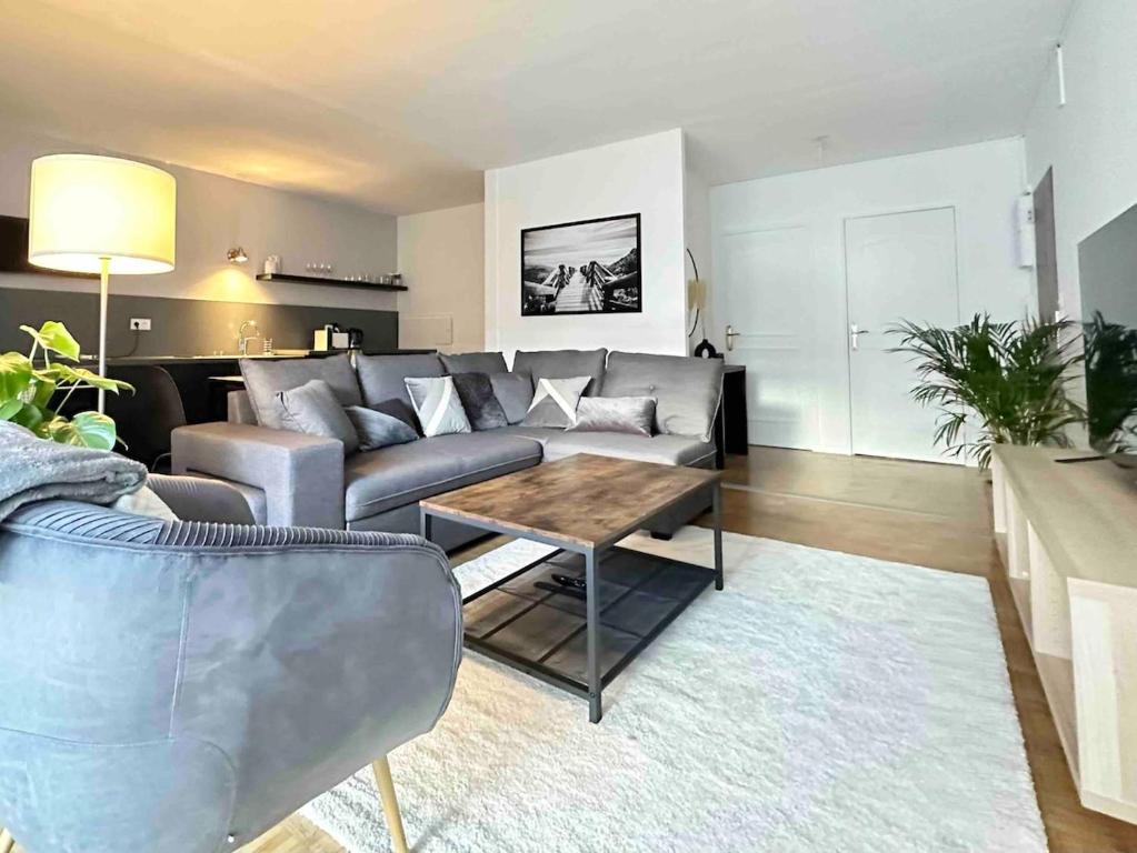 un salon avec un canapé et une table dans l'établissement Le carré Dijonnais - Spacious & parking included, à Dijon