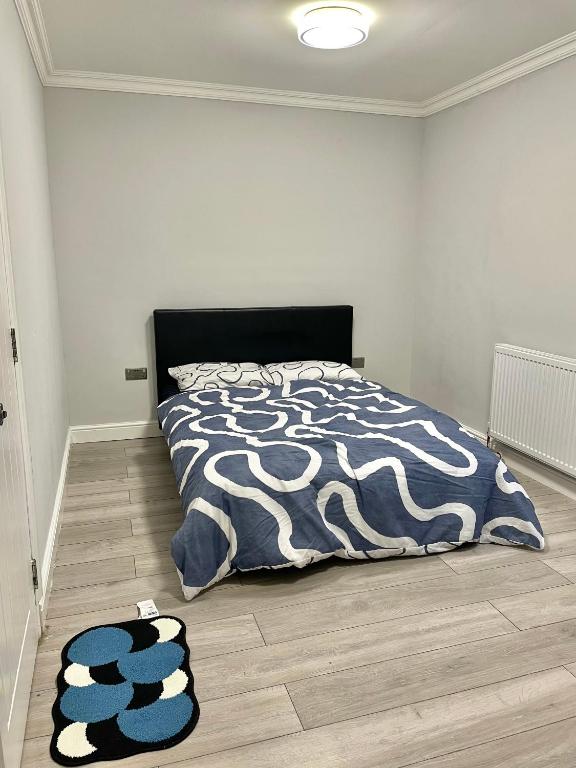 a bedroom with a bed and two rugs on the floor at Double Room in Colindale With Shared Bathroom in Colindale