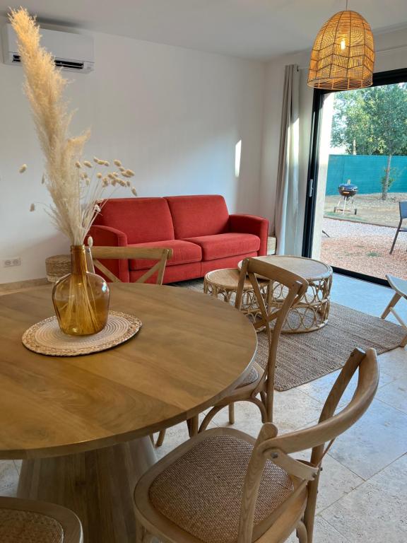 - un salon avec une table, des chaises et un canapé rouge dans l'établissement Villa roche blanche 2, à La Verdière