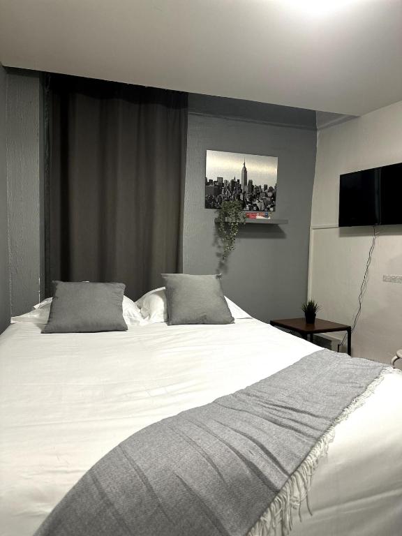 une chambre avec un grand lit blanc avec deux oreillers dans l'établissement La Clé Studio Proche Port - Gare - Wifi, à Toulon