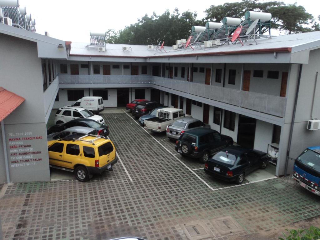a parking lot with cars parked in front of a building at Cabinas Dormi Bene in Miramar