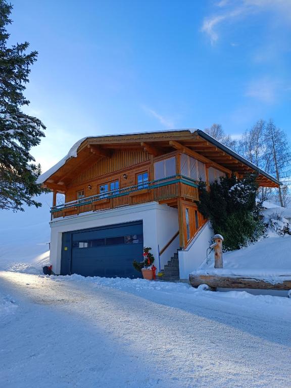 a house with a garage in the snow at Apartment Haus Klingspitz Pilzegg in Embach