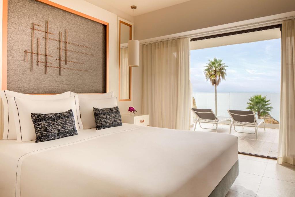 a bedroom with a large bed with a view of the ocean at Tivoli Carvoeiro in Carvoeiro