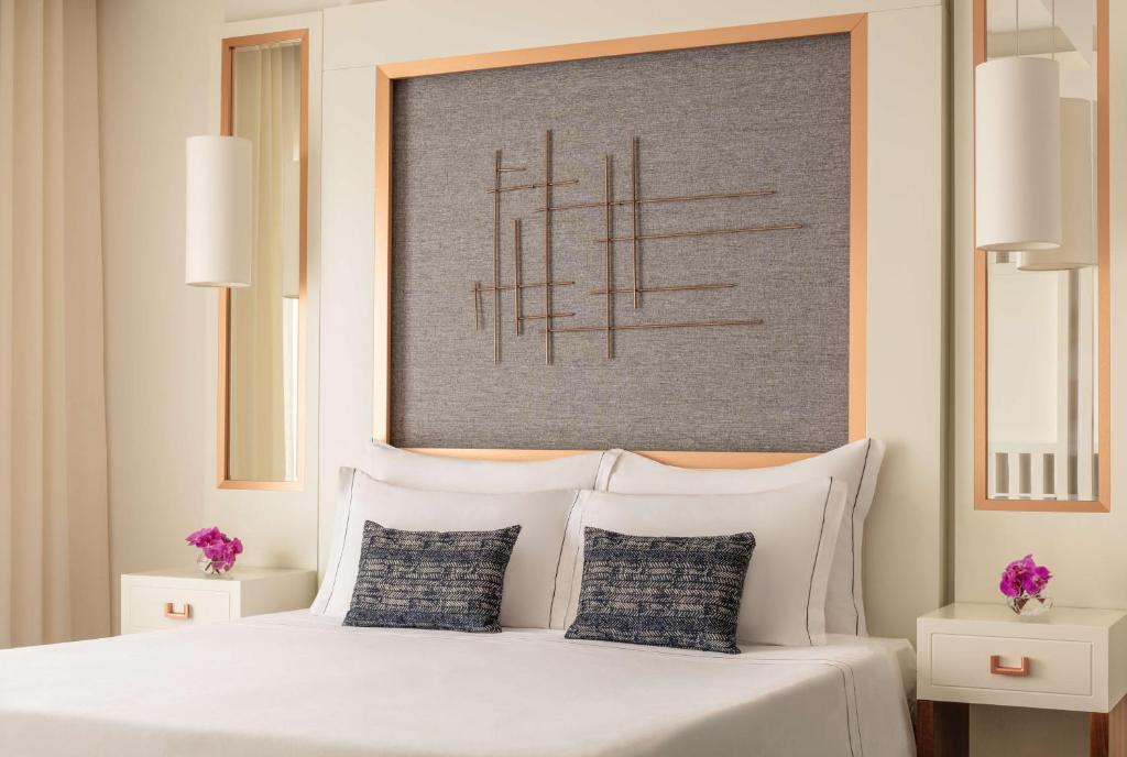 a bedroom with a white bed with two pillows at Tivoli Carvoeiro in Carvoeiro