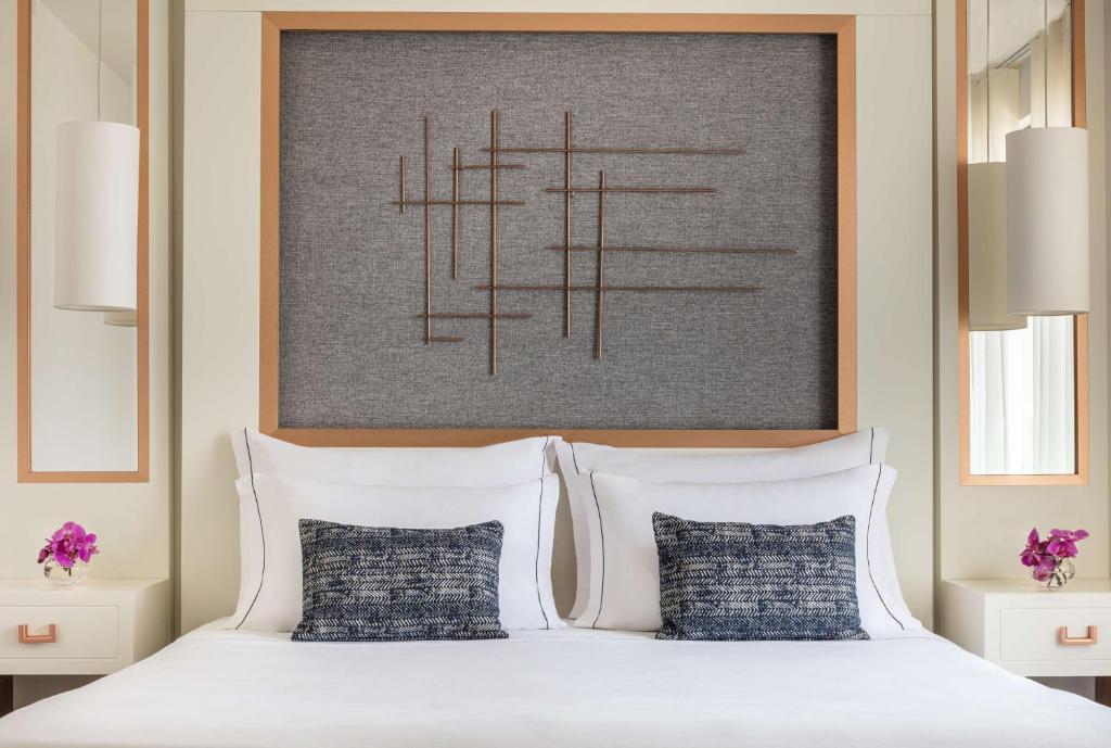 a bedroom with a white bed with two pillows at Tivoli Carvoeiro in Carvoeiro