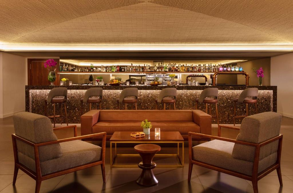 a bar with chairs and a couch and a table at Tivoli Carvoeiro in Carvoeiro