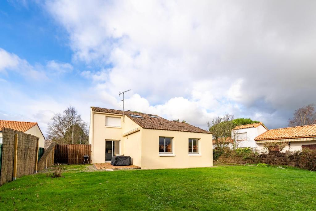 une maison dans une cour avec une pelouse verte dans l'établissement 128-Aux beaux volumes, proche plage, à Pornic