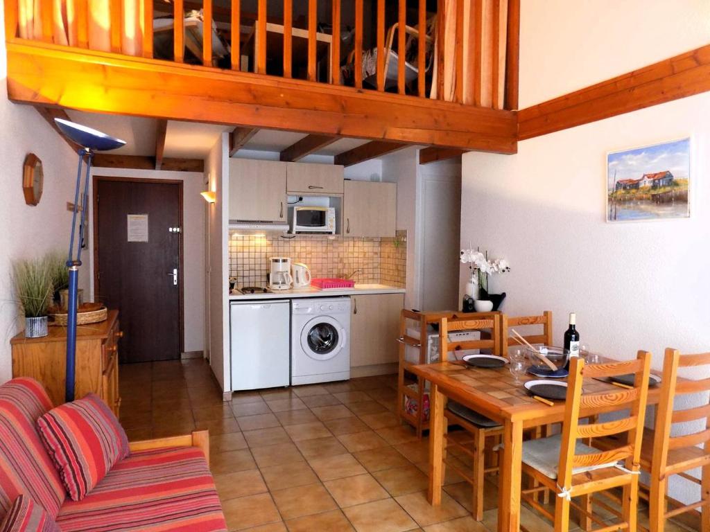 une cuisine et une salle à manger avec une table et des chaises dans l'établissement Saint Palais sur Mer - APPARTEMENT Les Flots Bleus - PLAGE du BUREAU, à Saint-Palais-sur-Mer
