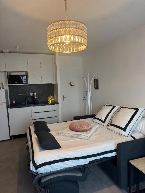 - une chambre avec un grand lit et un lustre dans l'établissement La Lumière du Coeur, à Saint-Philbert-de-Bouaine