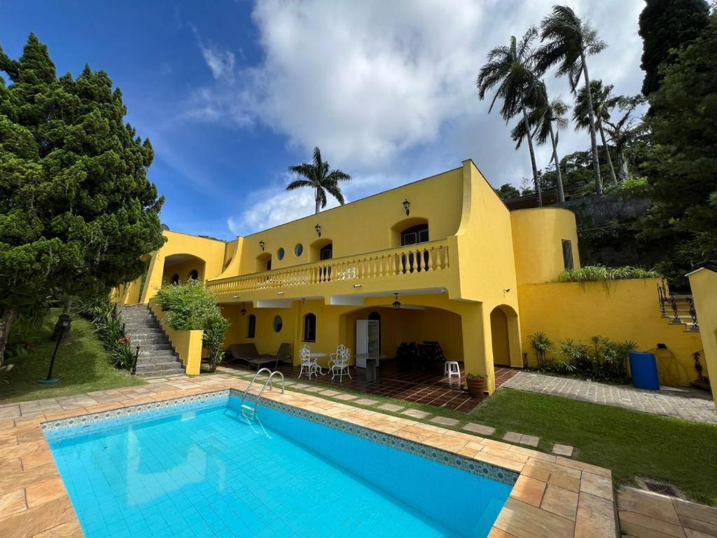 a house with a swimming pool in front of it at Casas de férias in Guarujá