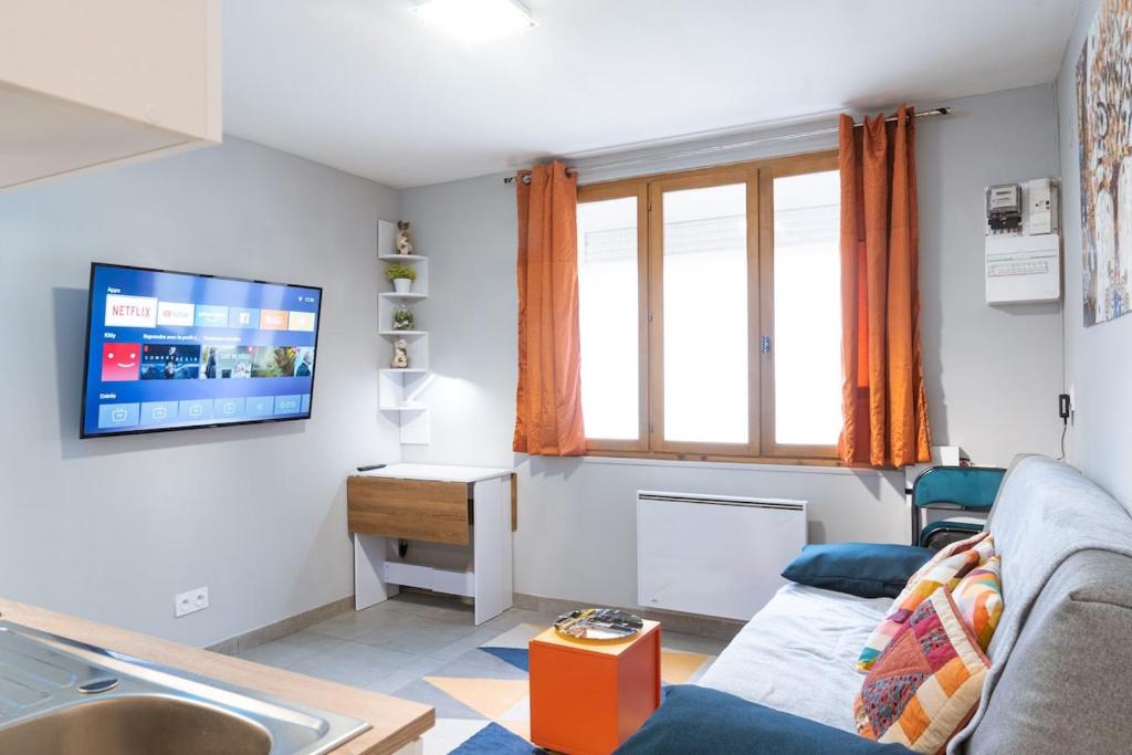 a living room with a couch and a tv on the wall at T2 a stone's throw from Gare Amiens in Amiens