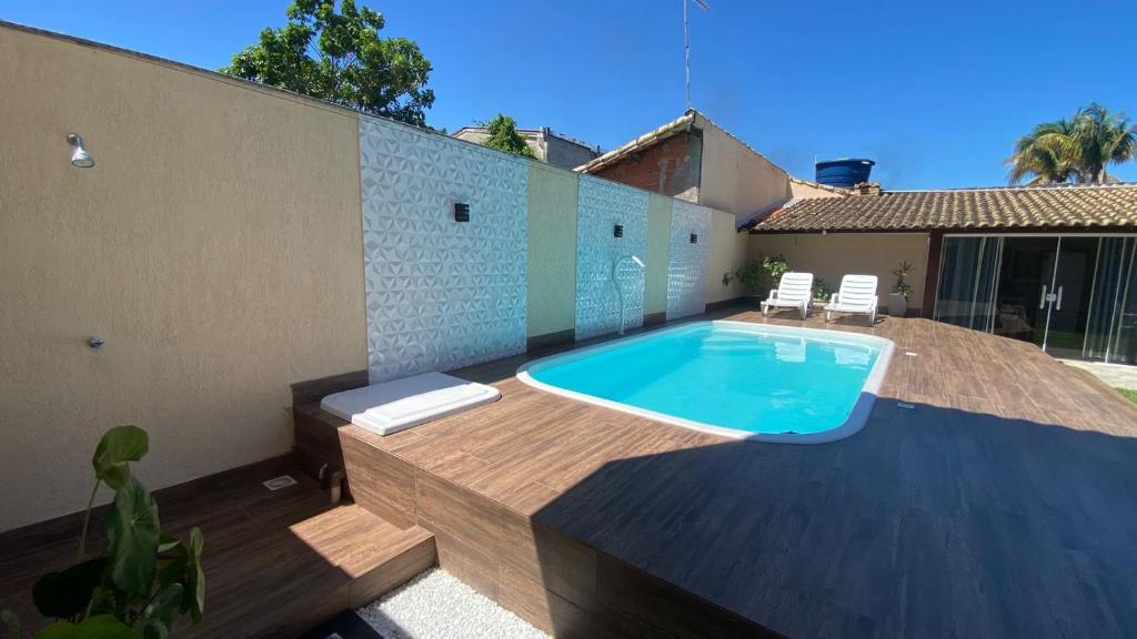 a swimming pool in a backyard with a house at CASA Secundaria COMPLETA COM PISCINA in Araruama