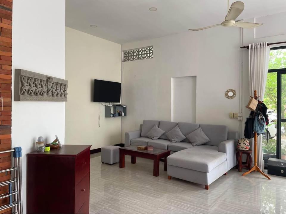 a living room with a couch and a tv at Private Room with in-suite Bathroom - Lovely House with Garden in Phumĭ Réach Born