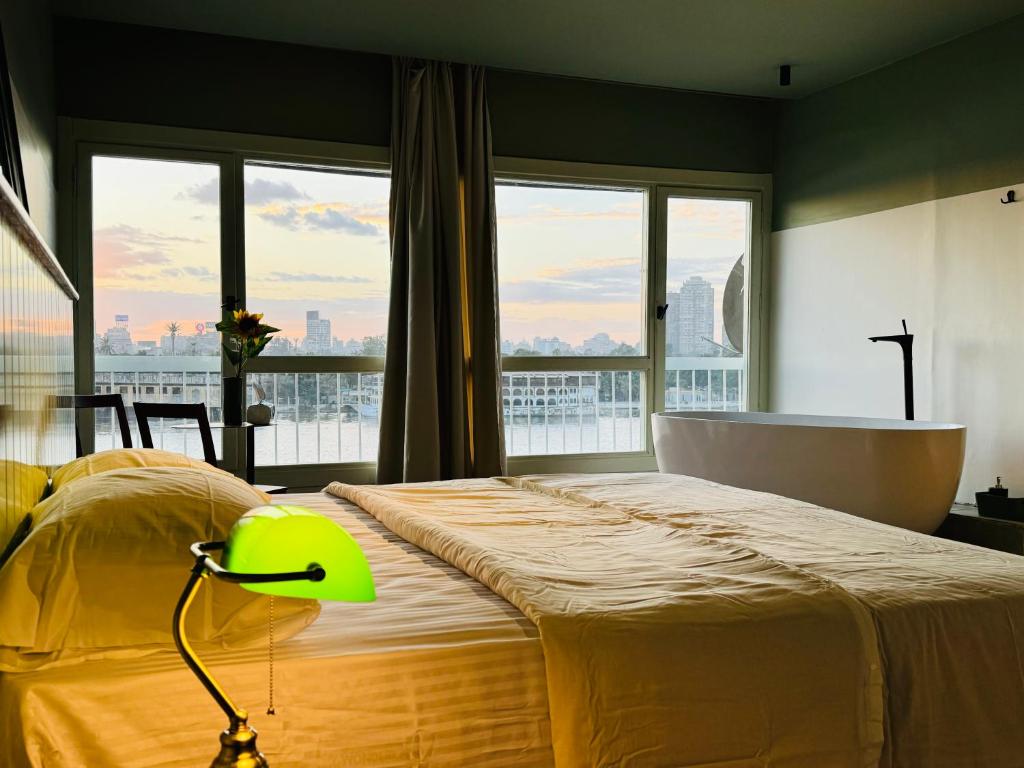 a bedroom with a bed with a tub and a window at Nile View Luxury Apartment in Cairo