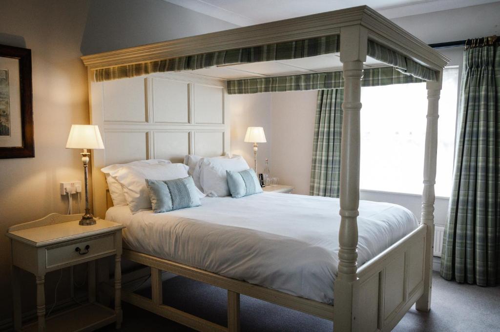 1 dormitorio con 1 cama blanca con dosel en Conyngham Arms Hotel, en Slane