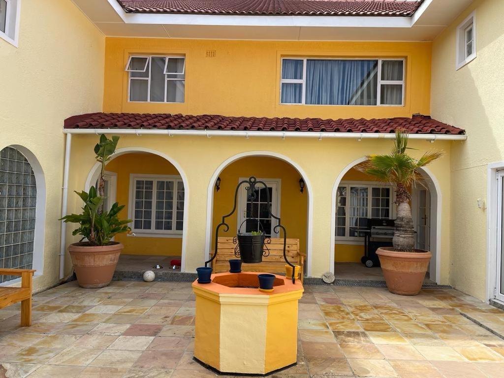 een geel huis met een fontein ervoor bij yalwa house in Sweet Valley