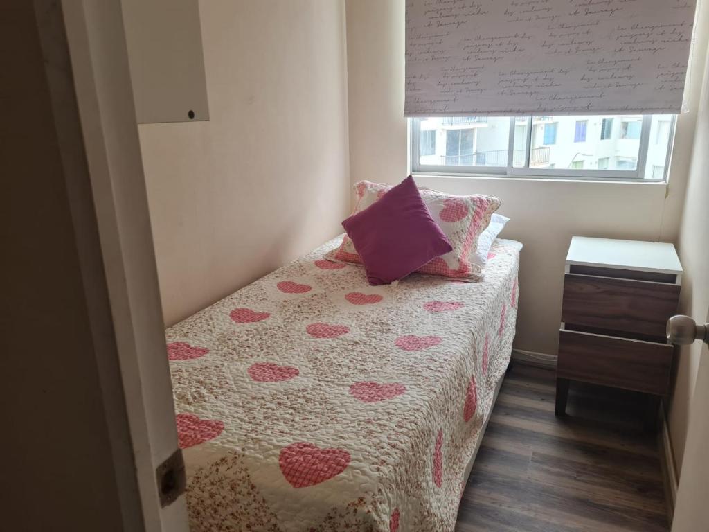 een kleine slaapkamer met een bed met harten erop bij olivos 1 in La Serena