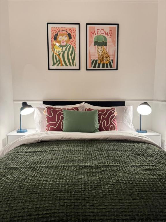 a bedroom with a large bed with three pictures on the wall at BIG House for Business Stays in Barnsley with 6-bedrooms & 8 Beds by PureStay in Barnsley