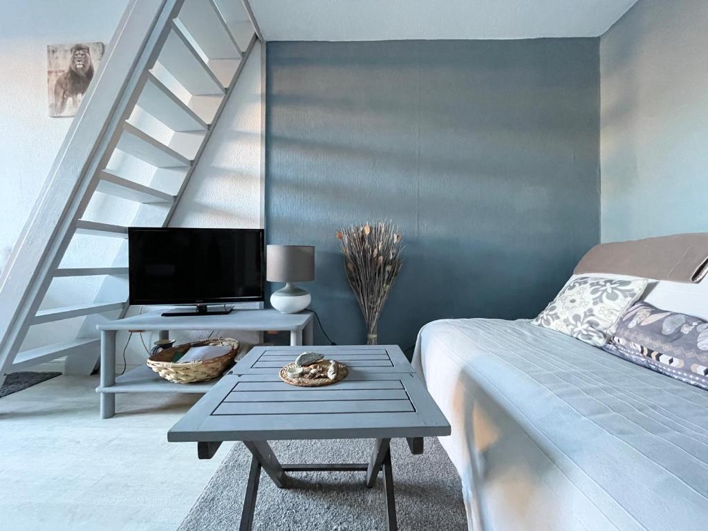 Cette chambre comprend un lit et une table avec une télévision. dans l'établissement Maison avec piscine clim parking, à Leucate