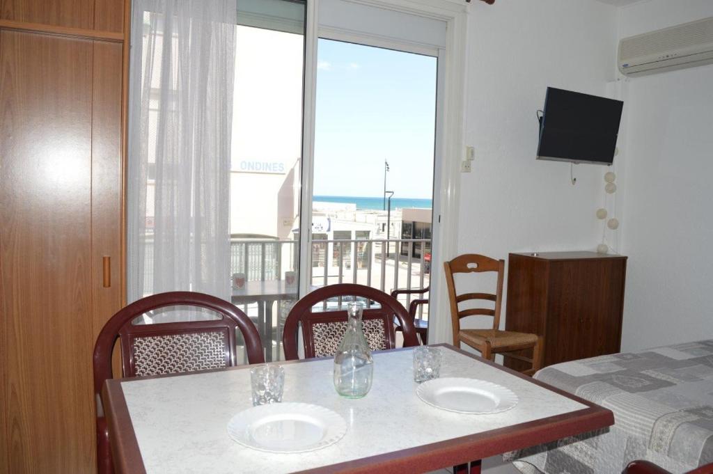 Cette chambre dispose d'une table, de chaises et d'un balcon. dans l'établissement Appartement studio 4 couchages SAINT CYPRIEN SC610-011, à Saint Cyprien Plage