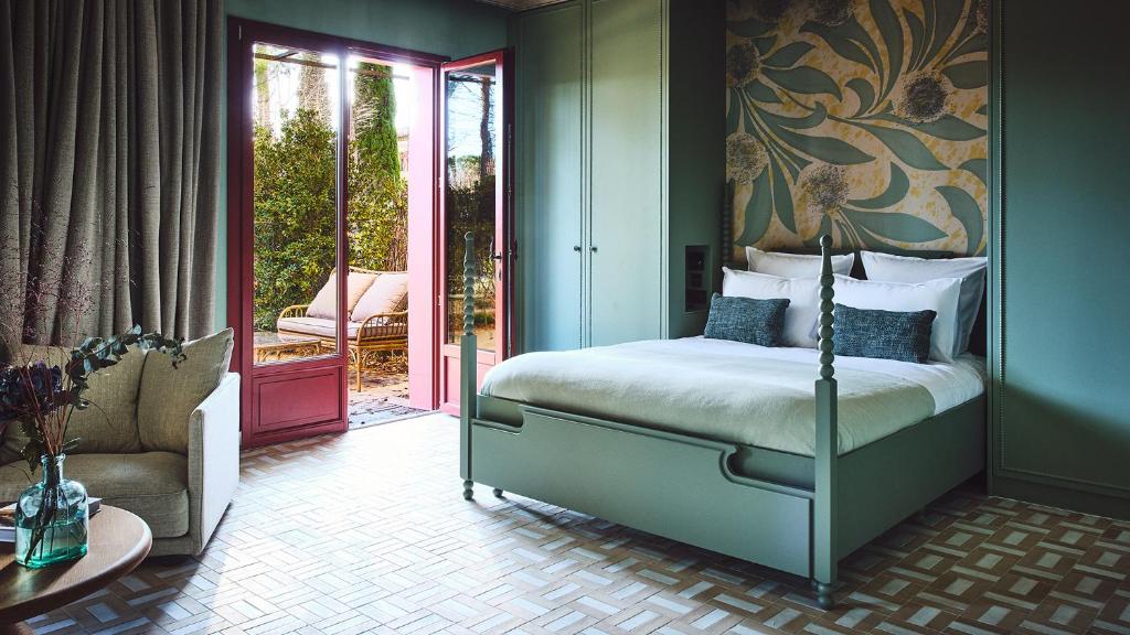 a bedroom with a bed and a chair and a door at Le Pigonnet - Esprit de France in Aix-en-Provence