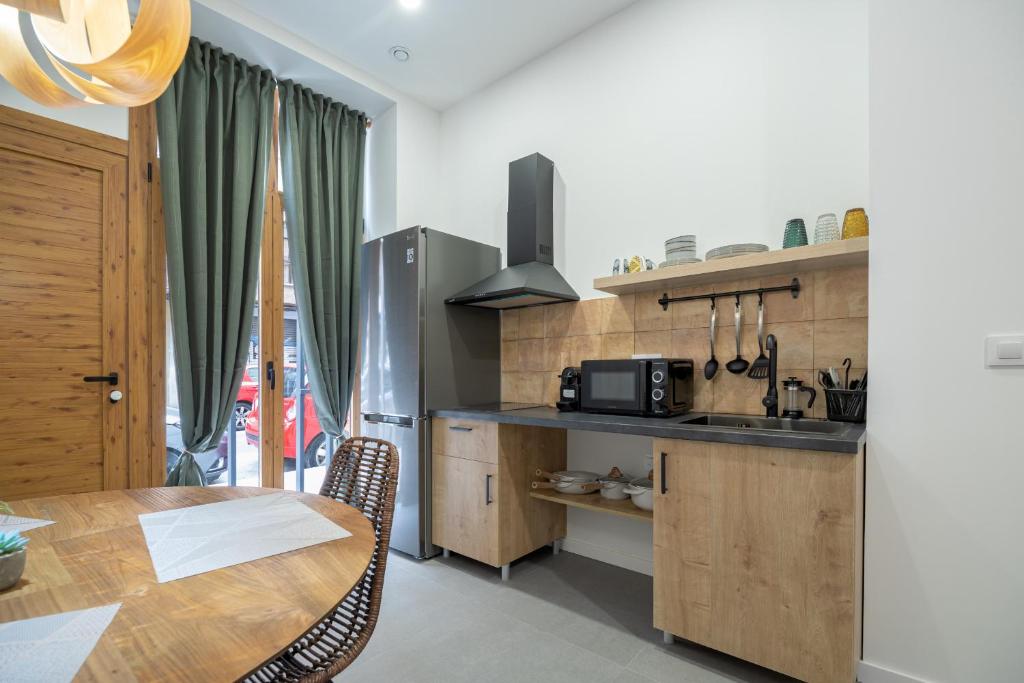 eine Küche mit einem Holztisch und eine Küche mit einem Esszimmer in der Unterkunft ESC - Loft Valencia Cómodos y espaciosos estudios cercanos a estación Joaquín Sorolla in Valencia