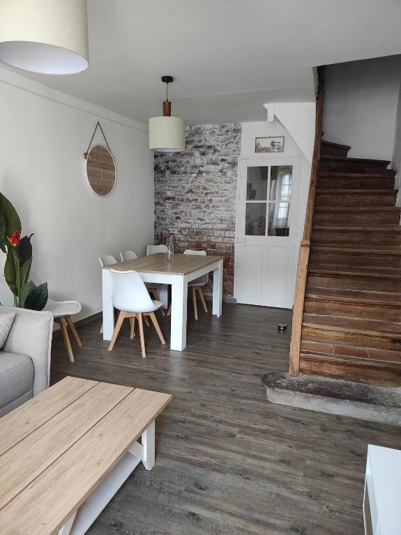un salon avec une table et des chaises et un escalier dans l'établissement La Conquête, charmante maison de caractère, à Conques-sur-Orbiel