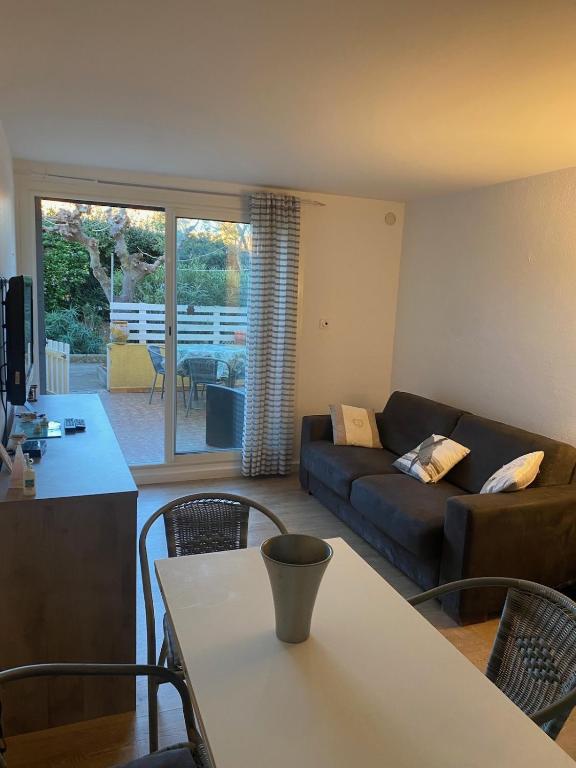 un salon avec un canapé et une table dans l'établissement Studio terrasse proche plage, au Cap d'Agde