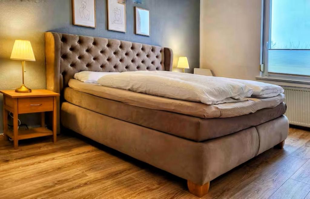 a bedroom with a large bed with a large headboard at HIRSCH FeWo Burgberg - Parkplatz - Zentral in Bad Harzburg