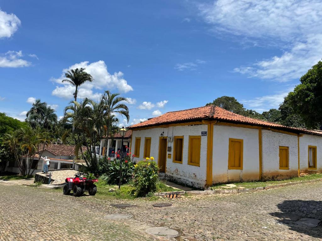 a small house with a motorcycle parked in front of it at HOSTEL DA LU e HOSPEDAGEM FATIMA in Pirenópolis
