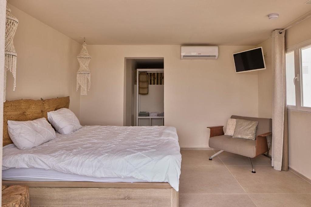 a bedroom with a bed and a chair and a television at Casa El Sueño in Jávea