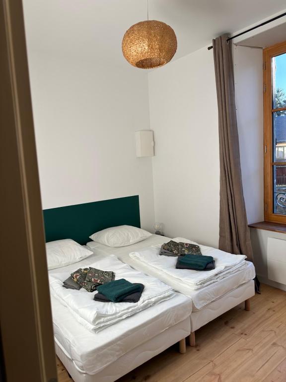 deux lits jumeaux dans une chambre avec fenêtre dans l'établissement Appartement face au château, à Murol