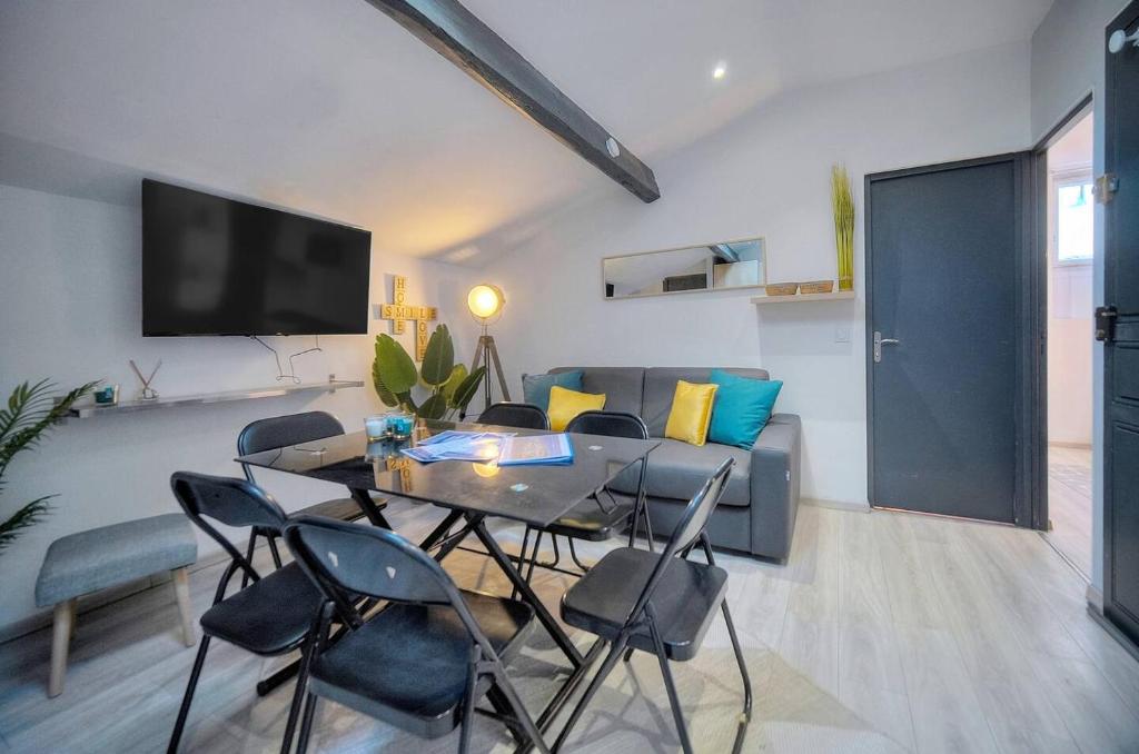 un salon avec une table, des chaises et un canapé dans l'établissement Le 8 - Cannes, à Cannes