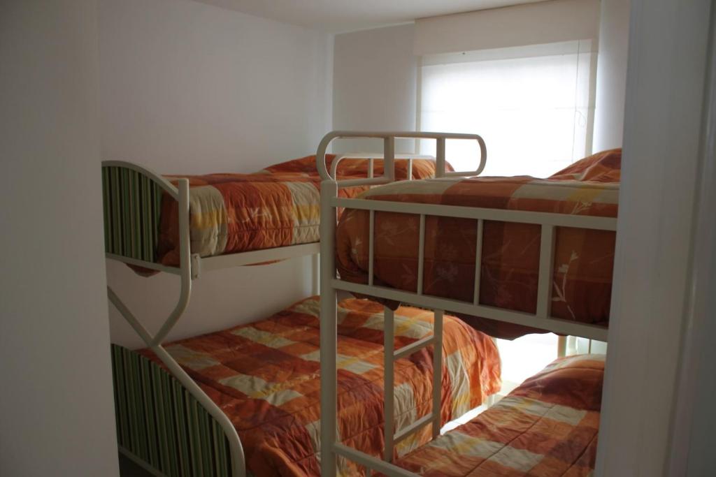 two bunk beds in a room with a window at Casa en condominio de playa para 12 personas, Asia in Rosario de Asia