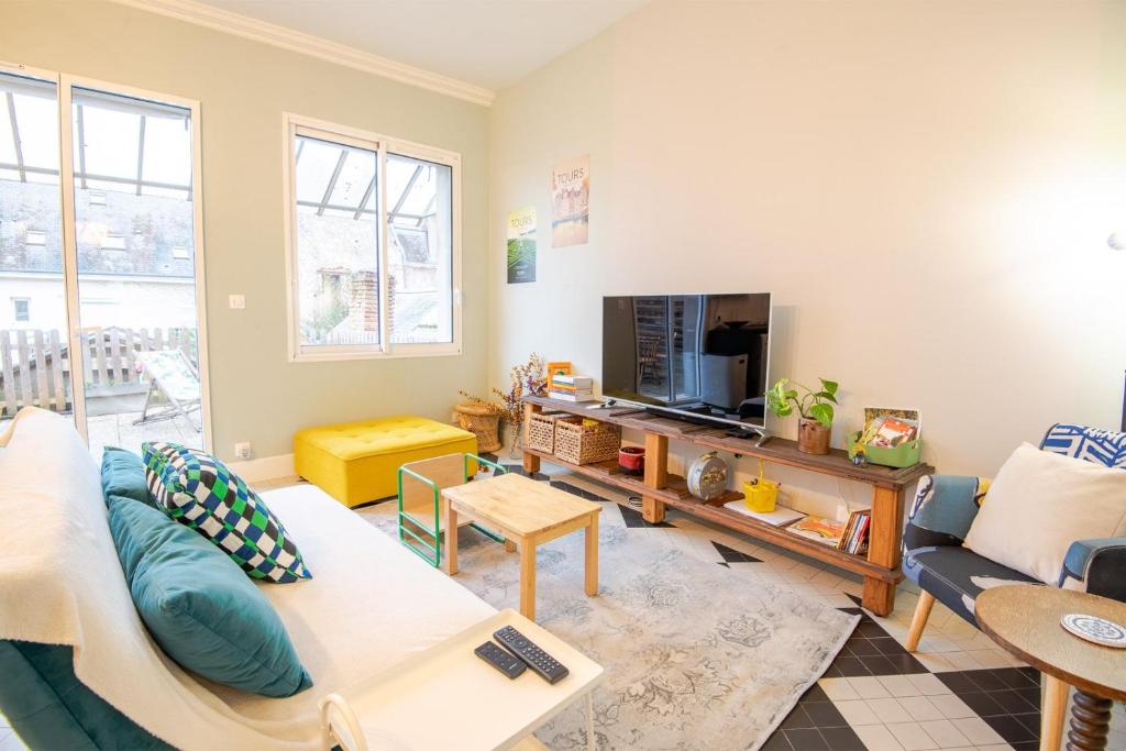 un salon avec un canapé et une télévision dans l'établissement Le 54 - Tours, à Tours