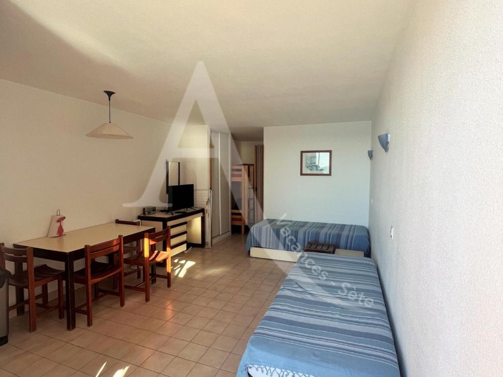 - une chambre avec un lit et une table dans l'établissement STUDIO 4 PERS RES 1ERE LIGNE MER AVEC PISCINE, à Sète