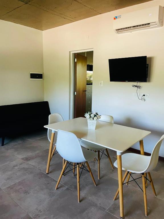 a dining room with a white table and chairs at Los plátanos 1 y 2 in Junín