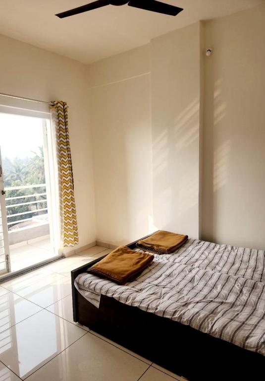 a bedroom with a bed and a large window at Be My Guest Homestay WHISPERING WIND in Kolhapur
