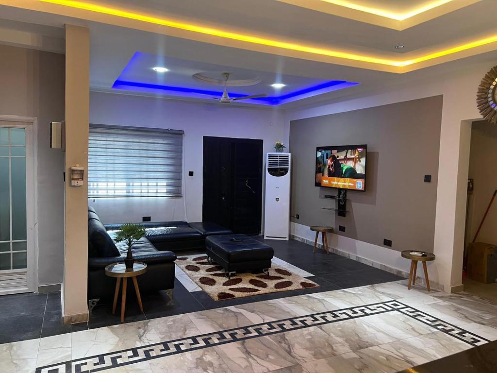 a living room with a couch and a tv at T-Roys Apartments in Accra